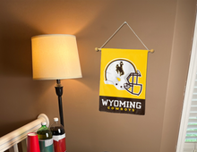Load image into Gallery viewer, Wyoming Cowboys Football garden flag hung on banner pole next to a lamp and drinks