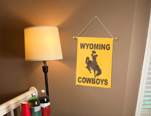Load image into Gallery viewer, wyoming cowboys garden flag hung on banner pole next to lamp and drinks
