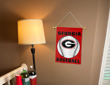 Load image into Gallery viewer, georgia baseball garden flag hanging on banner pole inside next to a lamp and drinks