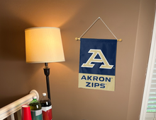 Load image into Gallery viewer, Blue & Gold 13x18 inch long Akron University Garden Flag with Akron Zips Logo hanging on a Banner Pole Inside a well-lit room