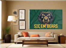 Load image into Gallery viewer, 3x5 Baylor University Flag with Bear Eyes and Sic Em Bears Logo covering the tan wall inside of a well organized room with couch pillows and light
