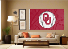 Load image into Gallery viewer, Red 3x5 University of Oklahoma Sooners Baseball Flag and Two Metal Grommets for indoor home decor covering tan wall of well lit room