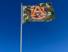 Load image into Gallery viewer, Camo 3x5 foot wide Auburn University Flag with orange and blue AU Logo and Two Metal Grommets attached to flagpole waving in the wind