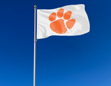 Load image into Gallery viewer, White 3x5 feet wide Clemson University Flag with Orange Paw and two metal grommets attached to flagpole waving in the wind
