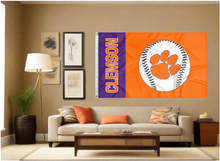 Load image into Gallery viewer, 3x5 foot wide Clemson University Baseball flag with two metal grommets covering the tan wall inside of a well organized room with couch pillows and light