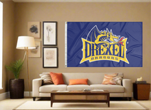 Load image into Gallery viewer, Blue 3x5 foot wide Drexel University Dragons Flag with Drexel dragons logo and two metal grommets covering the tan wall of the living room