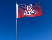 Load image into Gallery viewer, gradient style 3x5 University of Arizona Flag with two metal grommets attached to flagpole waving in the wind for outdoor home decor