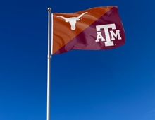 Load image into Gallery viewer, orange and maroon Texas Texas A&M House divided flag attached to flagpole waving in the wind