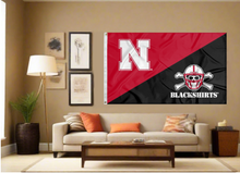 Load image into Gallery viewer, House Divided style Nebraska Huskers flag with N logo and Blackshirts logo hung inside living room