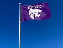 Load image into Gallery viewer, Purple 3x5 foot wide Kansas State University Flag with two metal grommets attached to flagpole waving in the wind
