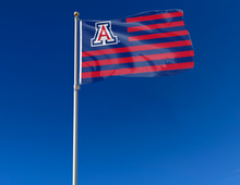 Load image into Gallery viewer, 3x5 University of Arizona flag with seven blue stripes six red stripes and two metal grommets attached to flagpole waving in the wind for outdoor home decor