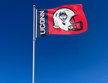 Load image into Gallery viewer, Navy and Red 2 panel 3x5 foot wide University of Connecticut (UCONN) Huskies Football flag with two metal grommets attached to flagpole waving in the wind