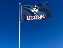 Load image into Gallery viewer, Navy 3x5 foot wide University of Connecticut (UCONN) UCONN Huskie Flag with husky uconn logo and two metal grommets attached to flagpole waving in the wind