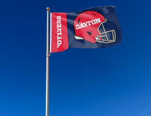 Load image into Gallery viewer, Blue and red two striped University of Dayton Flyers Football flag and two metal grommets attached to flagpole waving in the wind