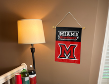 Load image into Gallery viewer, miami redhawks garden flag hung inside a college dorm for dorm decor