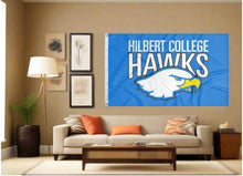 Load image into Gallery viewer, indoor display of blue hilbert college hawks flag for man cave decor