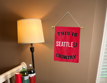 Load image into Gallery viewer, this is seattle university country garden flag hung inside a college dorm