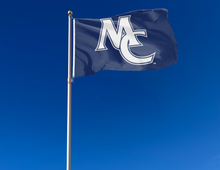 Load image into Gallery viewer, outdoor display of blue marietta college flag with mc logo for tailgate decor