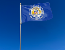 Load image into Gallery viewer, outdoor display of blue united states merchant marine academy flag with seal logo for tailgate decor