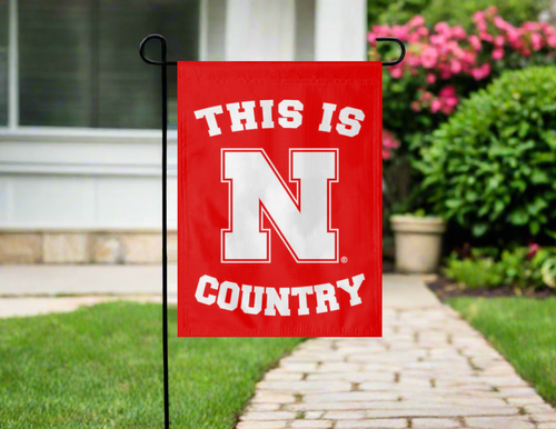 red university of nebraska country garden flag hanging in front of the yard