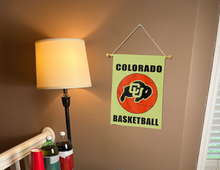 Load image into Gallery viewer, gold Colorado Basketball Garden Flag hung from banner pole inside the living room
