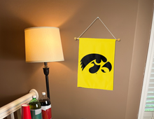 Load image into Gallery viewer, gold university of Iowa garden flag hanging on banner pole inside room
