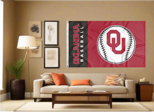 black and red University of Oklahoma baseball flag with two metal grommets covering tan wall of well lit room