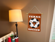Load image into Gallery viewer, texas longhorns soccer garden flag hanging on banner pole next to a lamp and drinks
