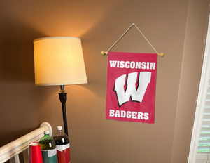 red university of wisconsin garden flag hanging on banner pole inside living room
