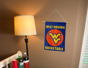 west virginia basketball garden flag hung on a banner pole next to a lamp and drinks