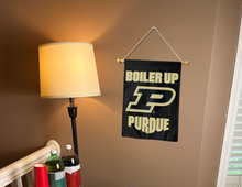 Load image into Gallery viewer, purdue garden flag with boiler up logo hanging on banner pole next to a lamp and drinks
