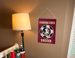 florida state fsu soccer garden flag hung on a banner pole next to a lamp and drinks