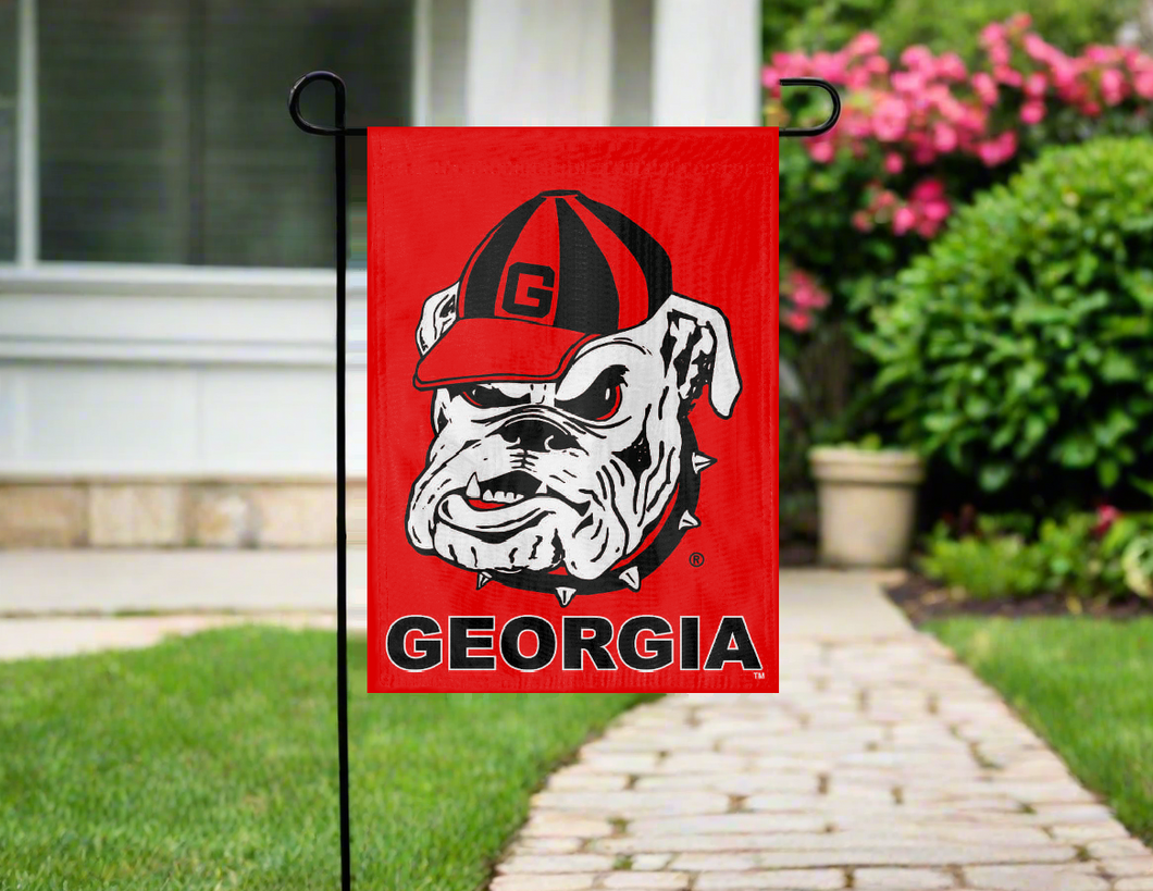 Georgia Bulldogs garden flag on a pole in front of a house with a pathway and flowers.