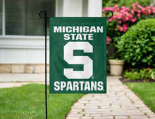 Load image into Gallery viewer, green msu garden flag hung outside from garden flag stand
