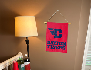 red University of Dayton Garden Flag hung from banner pole inside the living room