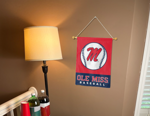 Red and blue Ole Miss Baseball Garden Flag hanging on banner pole inside room