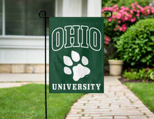Load image into Gallery viewer, green ohio university garden flag with paw logo hung outside from garden flag stand
