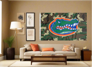 3x5 foot-wide University of Florida Flag with Camo Background and two metal grommets for indoor home décor covering tan wall of well lit room