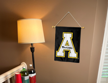 Load image into Gallery viewer, black appalachian state garden flag hung from a banner pole inside living room
