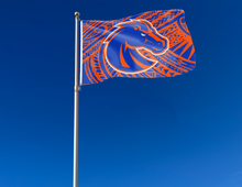 Load image into Gallery viewer, 3x5 foot wide Boise State University with Samoan pattern background and two metal grommets attached to flagpole waving in the wind
