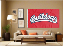 Load image into Gallery viewer, red Fresno State University 3x5 Flag with Bulldogs Logo for indoor home décor and two metal grommets covering tan wall of well lit room
