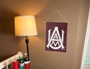 Maroon 13x18 inch long Alabama A&M University Garden Flag hanging on a Banner Pole inside a well lit room