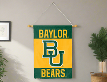 Load image into Gallery viewer, Green 30x40 inch long Baylor University 3 Panel House Flag hanging on banner pole covering a gray wall
