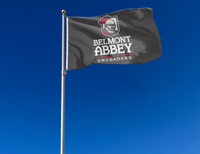 Load image into Gallery viewer, Black 3x5 foot wide Belmont Abbey College Flag with two metal grommets attached to flagpole waving in the wind
