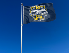 Load image into Gallery viewer, Blue University of Michigan 2023 College Football Playoffs National Champions 3x5 Flag with two metal grommets attached to flagpole waving in the wind
