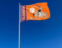 Load image into Gallery viewer, Purple and Orange 3x5 Clemson University Flag with Clemson Football Helmet Logo and two metal grommets attached to flagpole waving in the wind
