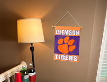 Load image into Gallery viewer, Clemson University Garden Flag with Purple and Orange Clemson Tigers Logo hung from banner pole inside living room
