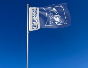 3x5 foot wide Blue and Gray 2 Panel Duke University Flag with Duke Logo Blue Devils Logo and two metal grommets attached to flagpole waving in the wind