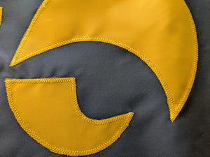 Close-up of a hand-sewn beak of University of Iowa Hawkeye logo of University of Iowa National Applique flag, showing the detailed stitching and fabric texture.