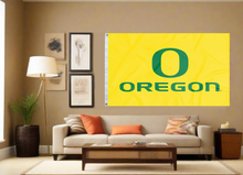 Load image into Gallery viewer, Gold University of Oregon Flag with O Oregon Logo hung inside living room behind a couch
